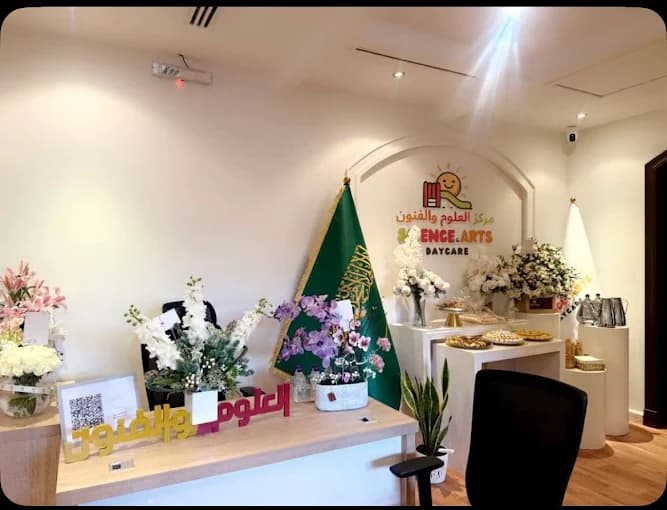 مكتب استقبال مركز العلوم والفنون مع الديكور والعلم السعودي والشعار