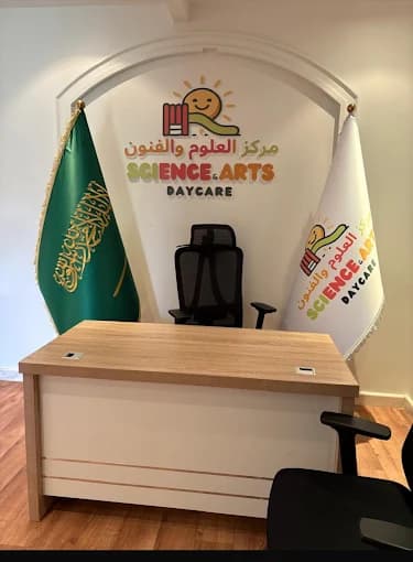مكتب استقبال مركز العلوم والفنون مع شعار المركز وعلم المملكة وعلم المركز