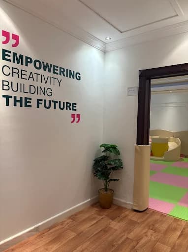 جدار في المركز بعبارة تحفيزية عن الإبداع وبناء المستقبل مع مدخل لمنطقة لعب