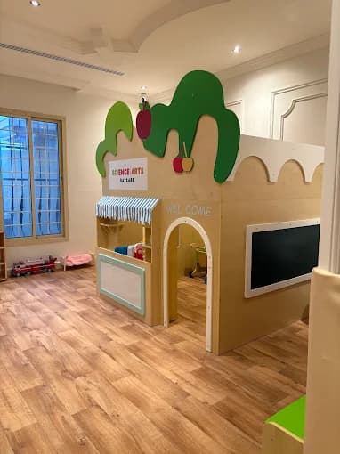 منطقة لعب داخل حضانة العلوم والفنون: بيت خشبي للعب مع لافتة Science Arts Daycare